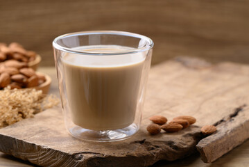 Almond milk in cup glass on wooden background, Alternative milk made from plant, non dairy