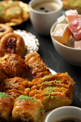 Delightful assortment of Middle Eastern sweets and pastries served on a table with coffee and fresh fruit