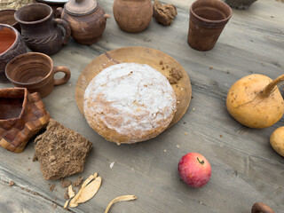 A wooden table with a plate of bread and a red apple