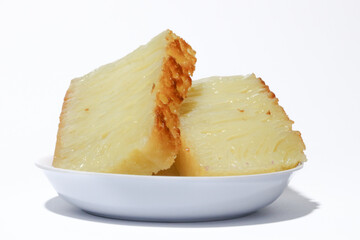 Bika Ambon, Indonesian honeycomb cake with square slices in white plate. It is made of flour, tapioca, coconut cream, lime leaf, and sugar.