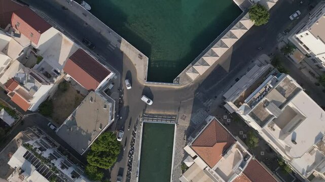 A top-down view of the iconic Bridge of Agios Nikolaos in Crete, captured as the drone ascends