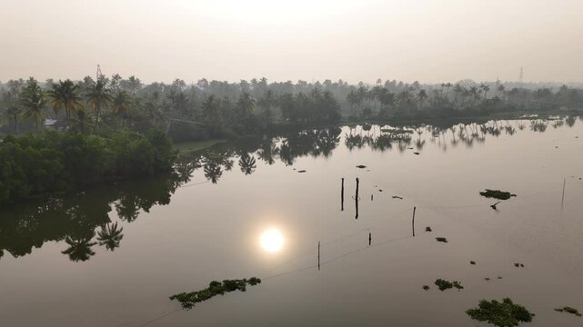 Kerala travel and tourism background, sunrise scene of Kerala backwaters with boat, Tropical river view with morning sunlight through palm trees