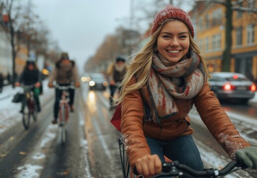 Woman rides bicycle through snowy city street with cheerful expression on a winter day - Powered by Adobe