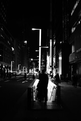 夜の街、地下道への階段を下りる人々