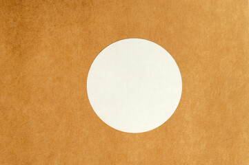 White round sticker on brown textured surface. Minimalistic product label concept