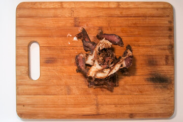 Fatty Biltong cured meat on a brown wooden cutting board.