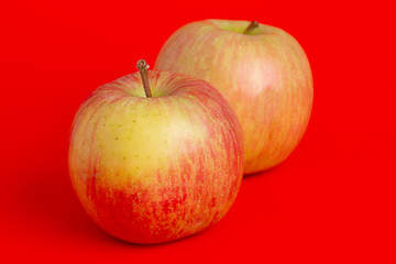 Two red apples on a red background. Fruits, apples.