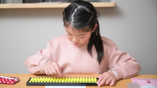 そろばん(珠算)をする小学生の正面の動画