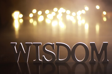 Wisdom Concept with Illuminated Letters and Abstract Light Bokeh Background