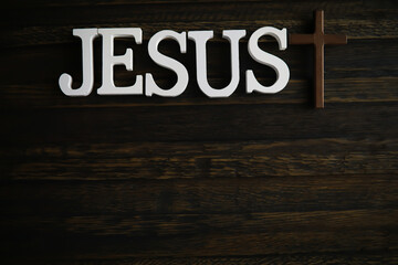 Wooden JESUS Sign with Cross on Dark Rustic Background - Religious Christian Symbolism in Stock Photography