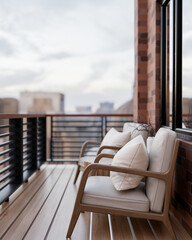 A side view of a contemporary, coy apartment balcony relaxation area featuring a city view.