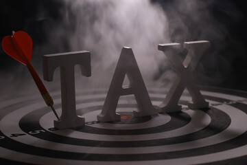 Tax Concept with Dart Hitting Target Bullseye in Smoky Background