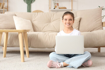 Fototapeta premium Teenage girl using laptop on floor at home