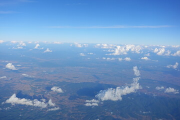Naklejka premium White clouds drift across the stratosphere against a blue sky. A few clouds dot the otherwise brilliant and pure sky. As if gazing up at a picturesque day, the scene is calm and tranquil.