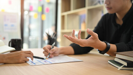 Close up of business colleagues exchange ideas and analyzing data during a meeting
