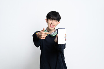 Smiling teenage man holding and pointing at smartphone with black screen for app promotions or tech advertisements