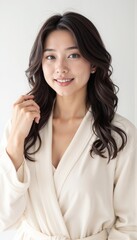 Elegant Asian woman in cream wrap blouse against grey background