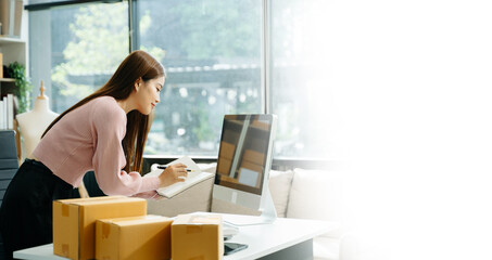 Business owner woman prepare parcel box and standing check online orders for deliver