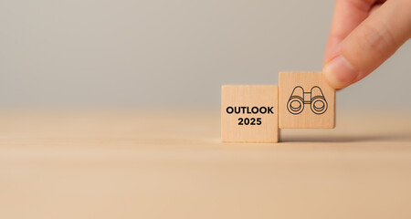 Economic, business outlook concept. Financial, business view or economic growth forecast for 2025. OUTLOOK 2025 text and binoculars icon on wooden cube blocks, copy space and minimal background.