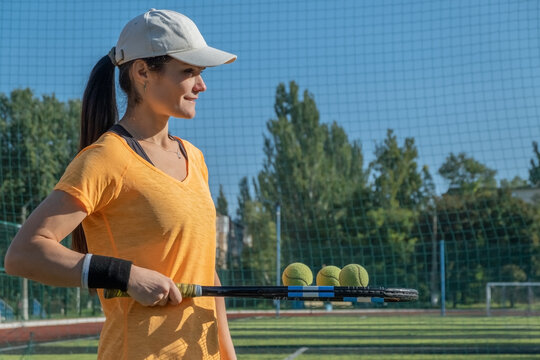 Young Female Tennis Player Holds Balls On Racket Before Serving