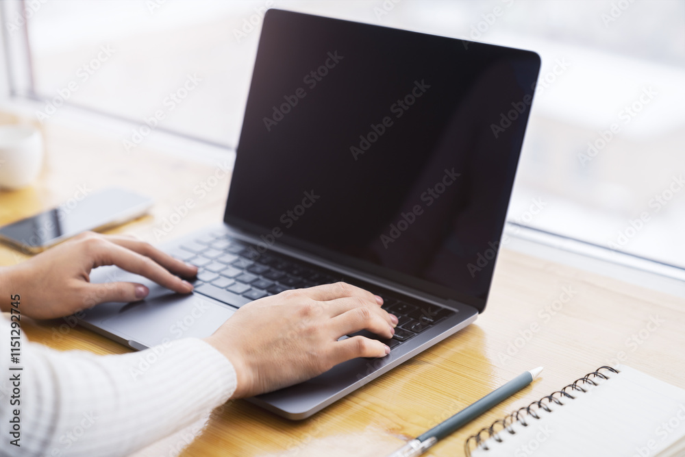 Poster a close-up view of female hands typing on a state-of-the-art laptop keyboard, with a blurry office s