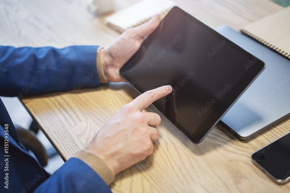 Poster closeup of a man's finger making contact with a state-of-the-art tablet screen, device resting on a 