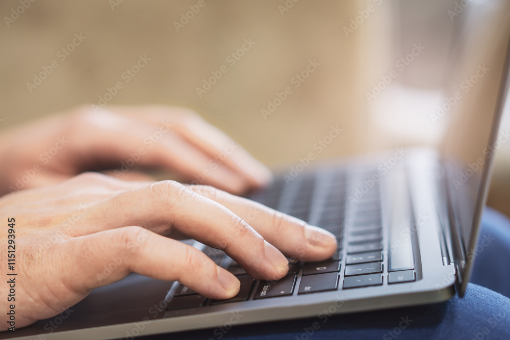 Poster in a close-up, a man's hands can be seen typing on a modern laptop keyboard, with the office setting
