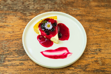 Cheesecakes with mix berry sauce in the plate.