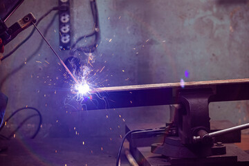 Welding Ideas and concepts. Professional Male Welder in Protective Mask During Welding Process of Metal