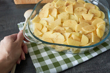 Potato wedges in a glass bowl on a wooden table.
