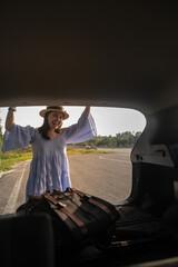 Fototapeta premium Smiling Woman with Backpack by Car on Scenic Road