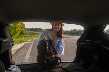 Smiling Woman with Backpack by Car on Scenic Road
