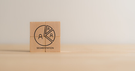 Market Segmentation Concept. Wooden blocks arranged to depict a pie chart representing market segmentation, with icons of customer groups. Identify different customer groups, STP marketing model.