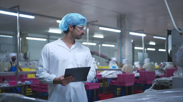 Production control supervisor inspects and controls the operation of each step in the production line of a canned fish factory