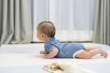 Fototapeta premium Happy baby playing on soft play mat indoors