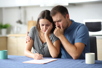 Sad couple reading paper contract