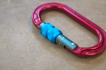 Fototapeta premium Climbing red carabiner on a gray background close-up, selective focus