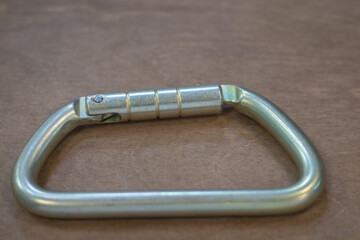 Climbing carabiner on a gray background close-up, selective focus
