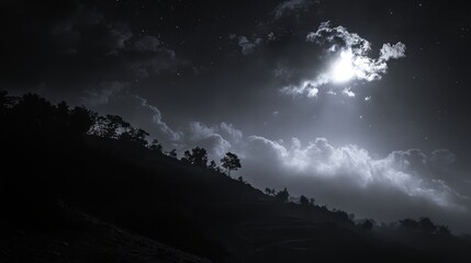 A gentle hillside bathed in moonlight, with scattered clouds adding depth to the serene night sky.