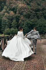 The bride and groom are running along the path