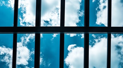 Fototapeta premium Cloudy sky with shades of blue visible through bars, creating a striking contrast between the blue sky and the metal structure. The blue and cloudy sky captivates the viewer s attention.