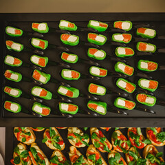 Platter of gourmet appetizers featuring pieces of salmon and cream cheese wrapped in a green wrap