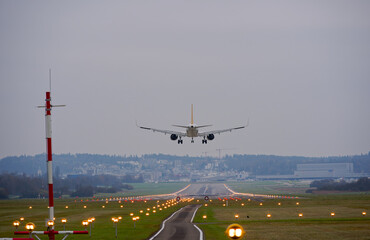 Rear view of passenger airplane landing at Swiss Airport Zürich Kloten on a cloudy autumn day....