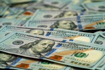 Close-up view of stacked hundred dollar bills on a flat surface