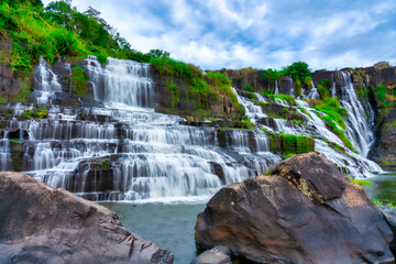 Mystical waterfall with foreground is autumn leaves in the Da Lat plateau, Vietnam. This is known as the first Southeast Asian waterfall in the wild attracted many tourists to visit