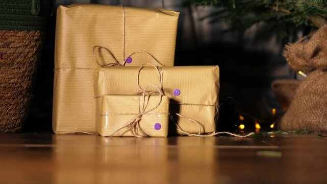 Gift wrapped in brown paper and string with Christmas lights bokeh background