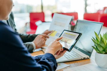 Business colleagues analyzing data on laptop and digital PC in office