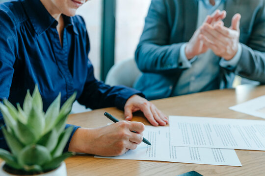 Businesswoman signing documents with colleague in office
