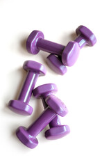 Many lilac dumbbells lie on white background, isolate