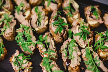 Gourmet bruschetta appetizers featuring slices of bread topped with meat, arugula